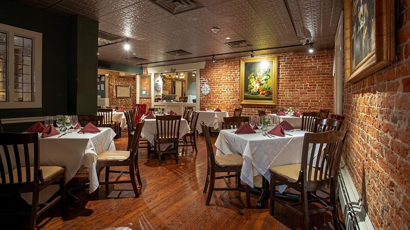 Dining room with brick wall and many set tables