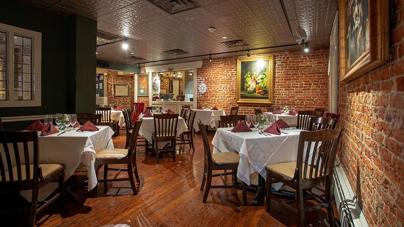 Dining room with brick wall and many set tables