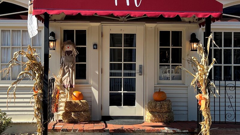 Outdoor entrance with pumpkin and corn stalk decoration