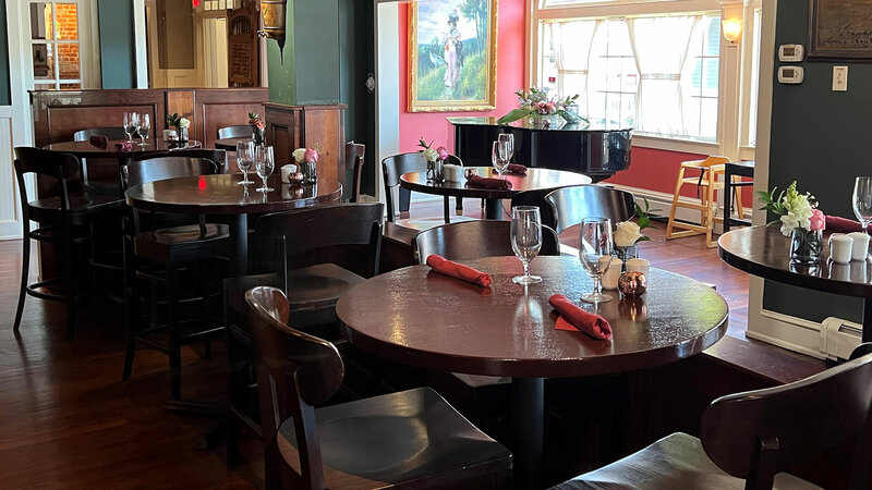 Bar seating area with view of piano